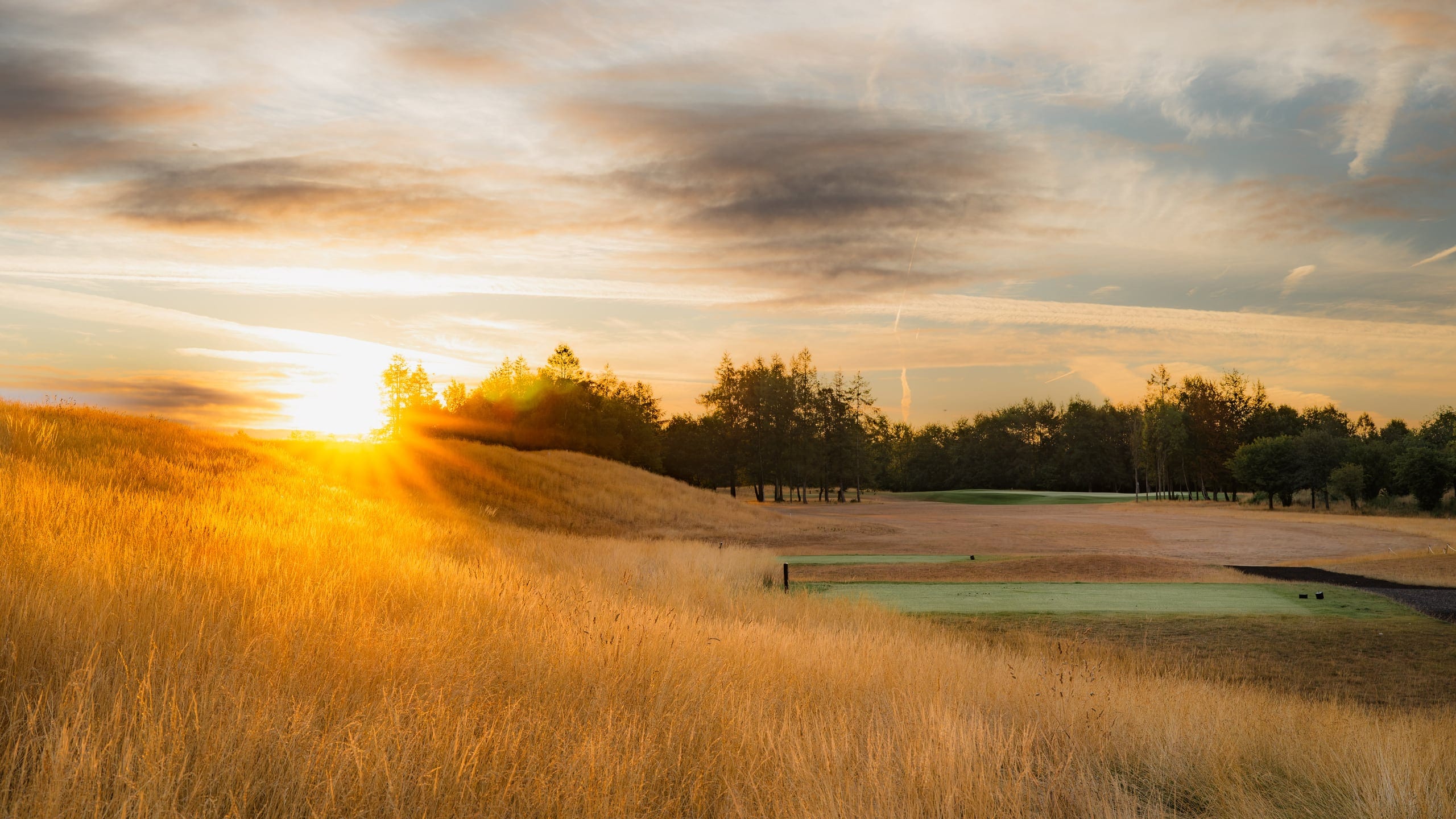 The sun setting straight down a fairway