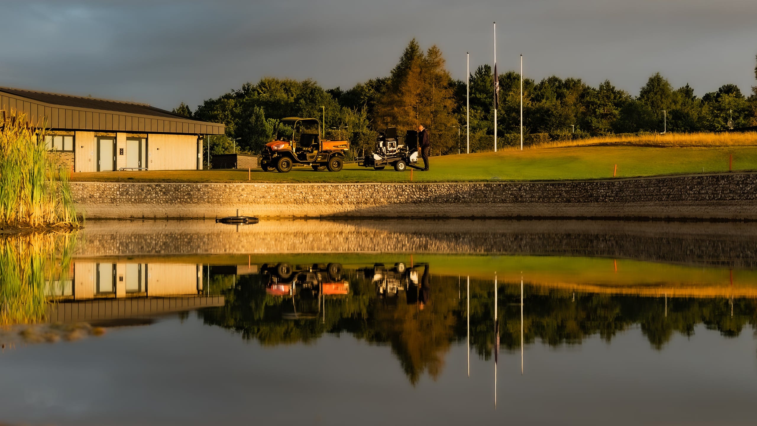 The clubhouse reflected in still water at golden hour