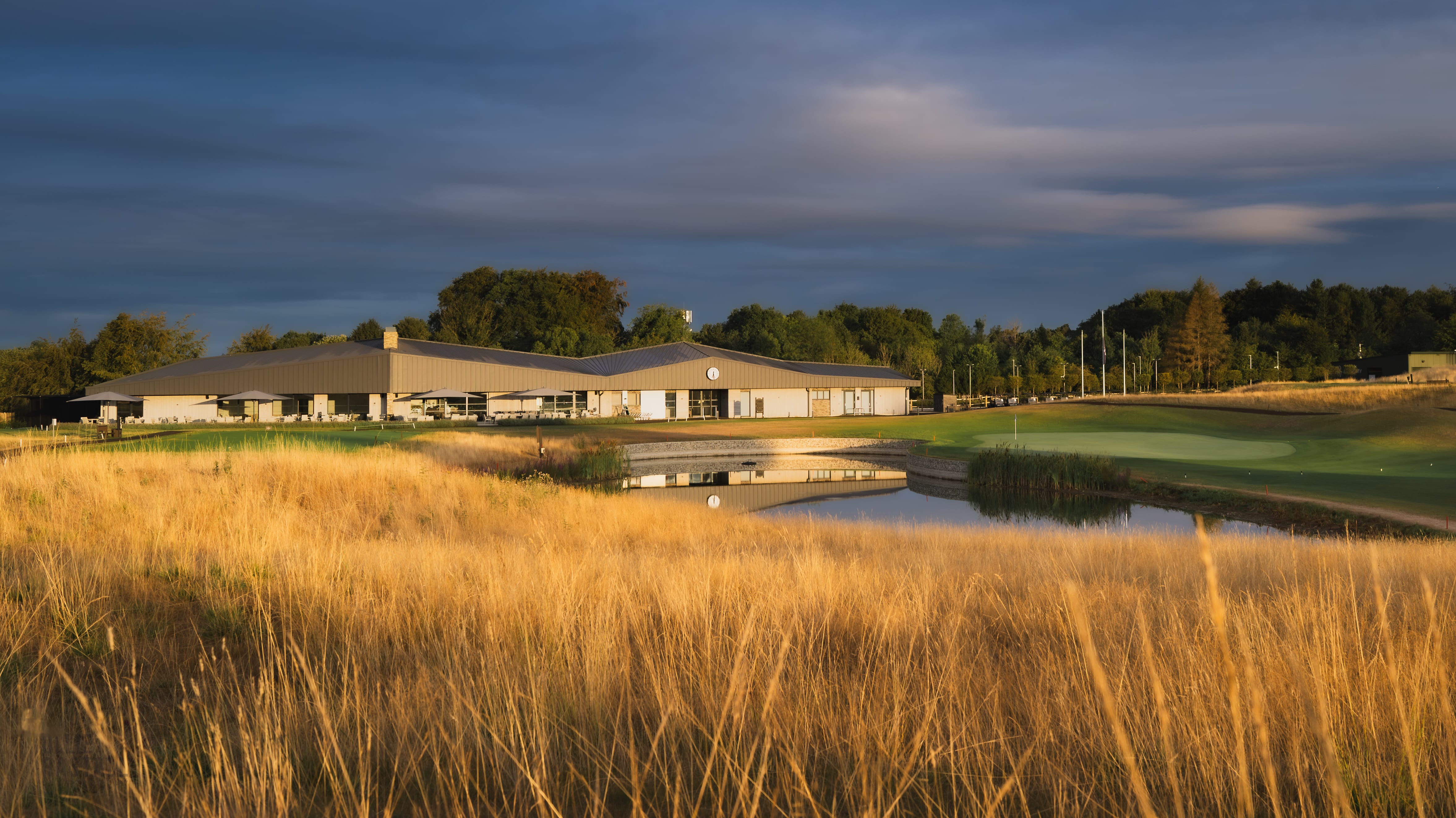 The clubhouse reflected across the pond at blue hour