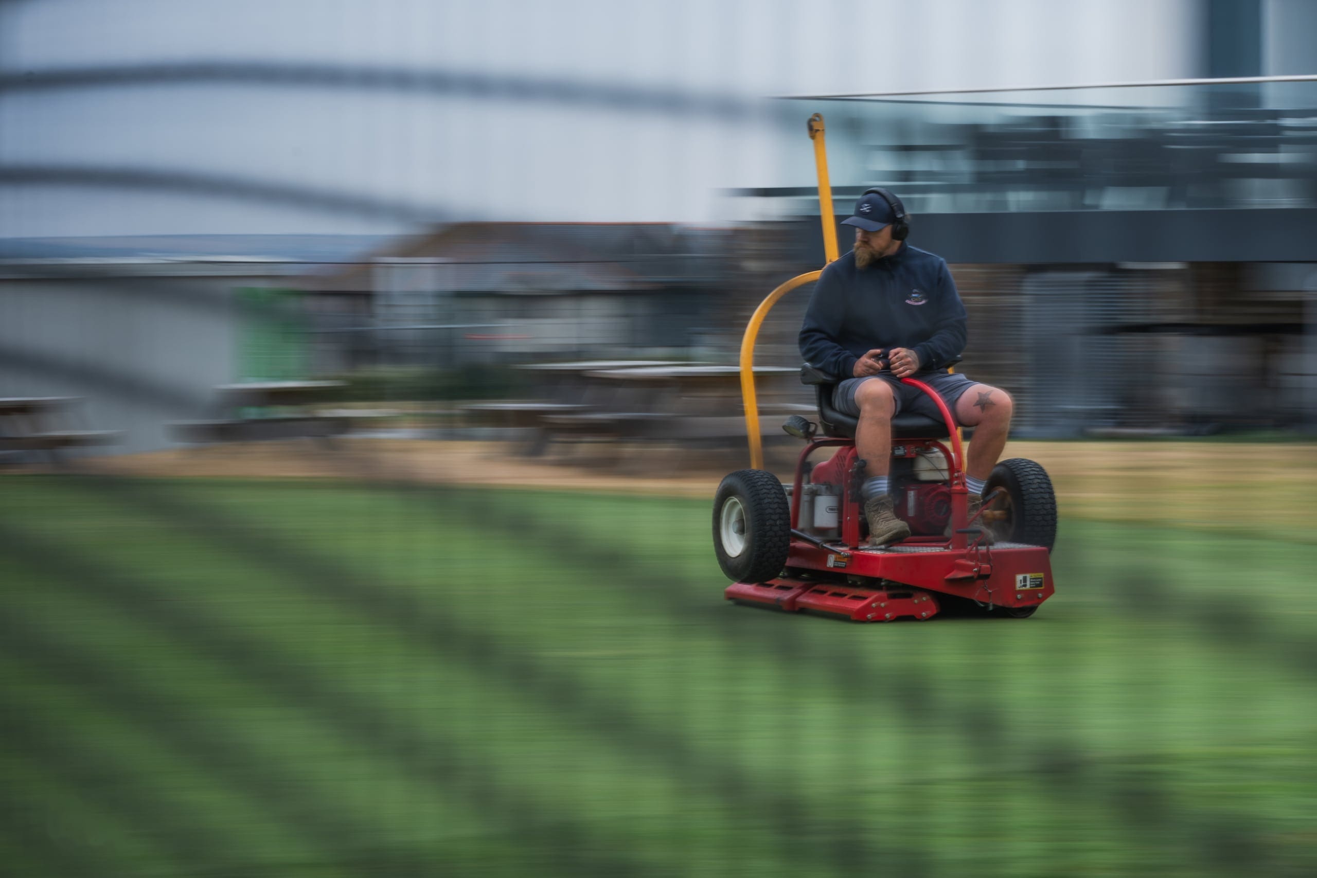 A mower crossing a green, caught with motion blur