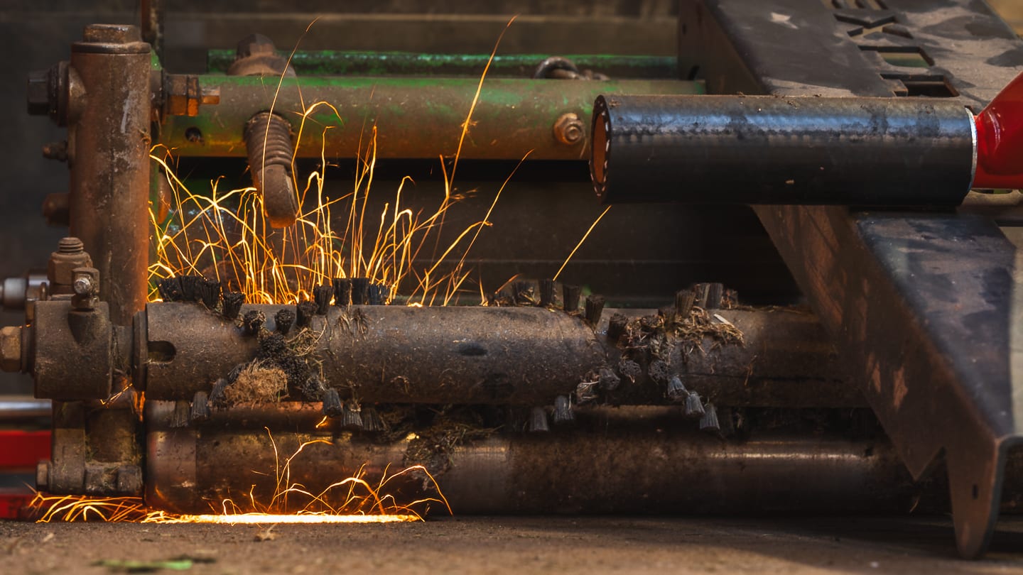 Sparks flying as a mower cylinder is reground in the workshop