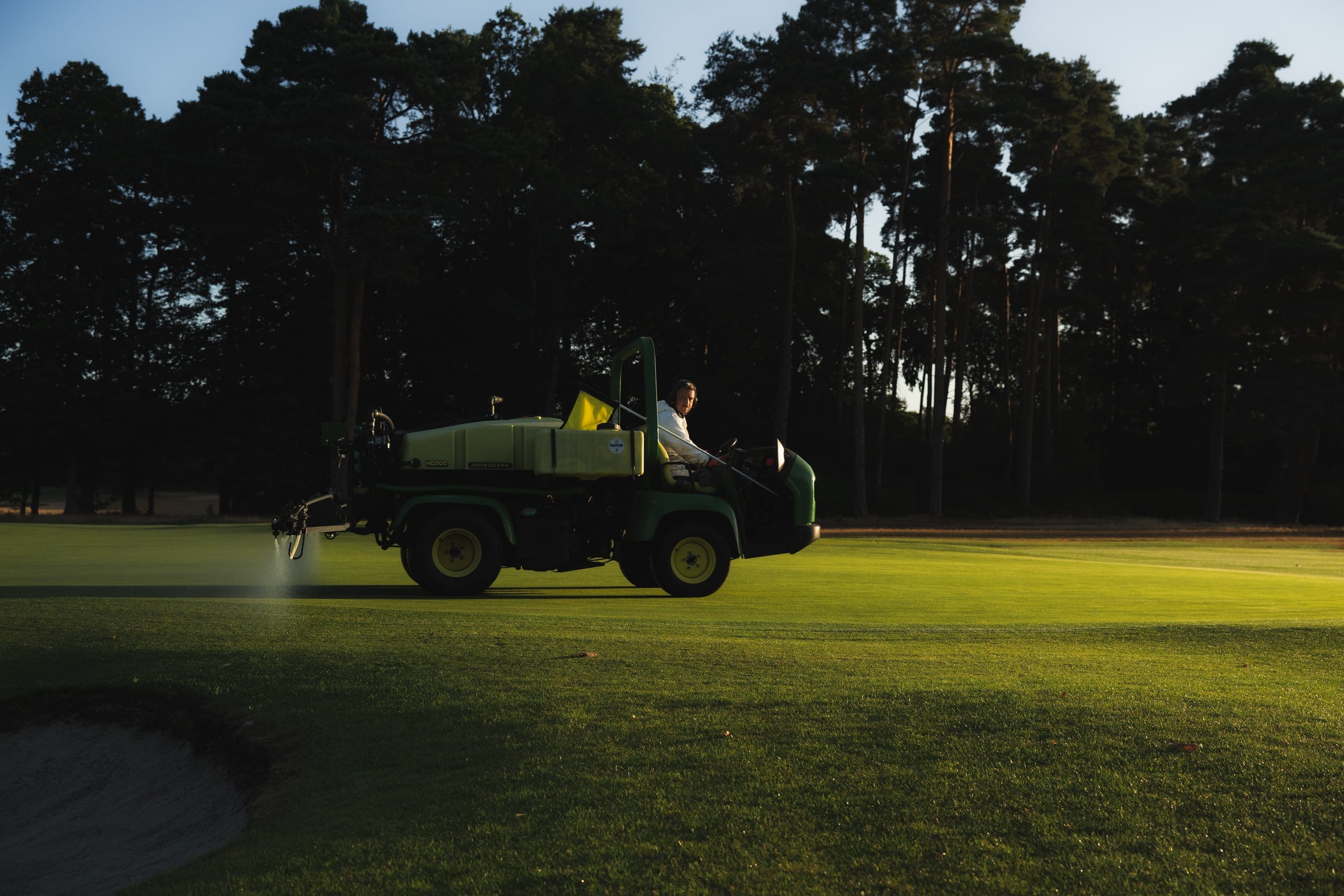 A utility vehicle parked on the course at dusk
