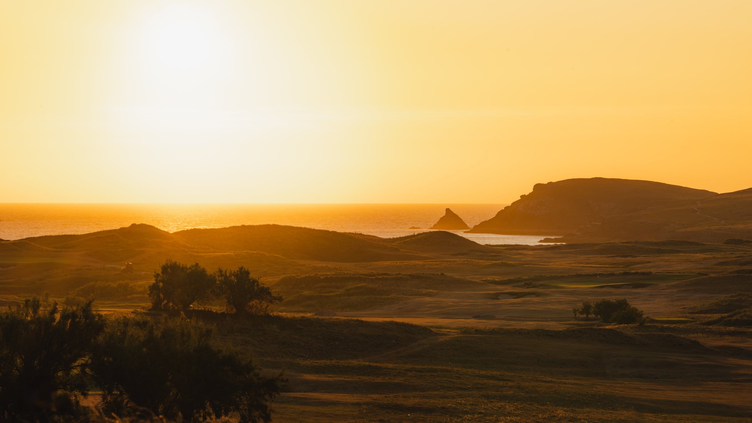 The sun going down over the headland